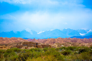 Naklejka premium Natural unusual landscape of red rocks against the backdrop of blue mountains. The extraordinary beauty of nature is similar to the Martian landscape. Amazingly beautiful landscape.