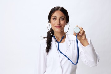 Woman doctor with stethoscope in hand in medical gown on white nurse background, consequences of covid-19, noise in lungs, concept of health and science