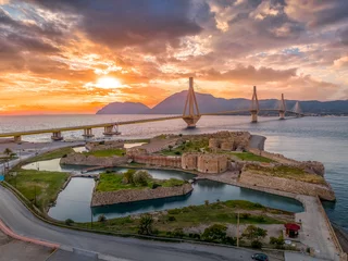 Fotobehang Aerial view of Rio (Rion) fortress near Patras and the Rion-Antirion bridge Greece protecting and crossing the entrance to the Gulf of Corinth with magical colorful sunset © tamas