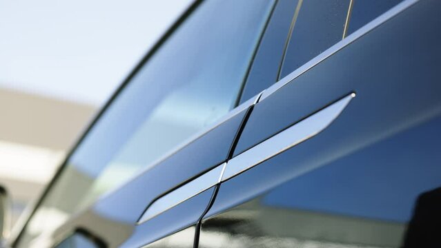 Electric car door handle. A man, a driver, a buyer closes the driver's seat door. Car dealership, car business