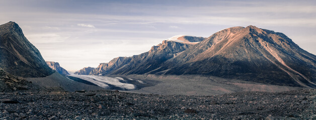 Sunset over the remote arctic valley of Akshayuk Pass, Baffin Island, Canada. The last rays of light on the peaks around Highway Glacier. Arctic summer in the wilds of the far north.