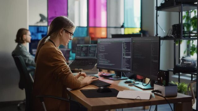 Professional Female Backend Software Developer Coding on Desktop Computer With Two Displays in Creative Office.Caucasian Woman Creating User Data Base for New Social Network Website or Online Store.