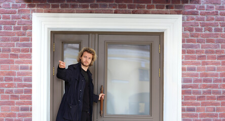 young man opening the door of his house.Inviting the guests