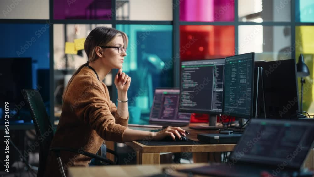 Poster Female Junior Software Engineer Writes Code on Desktop Computer With Two Monitors and Laptop Aside In Stylish Office. Caucasian Woman Working On Artificial Intelligence Service For Big Tech Company.