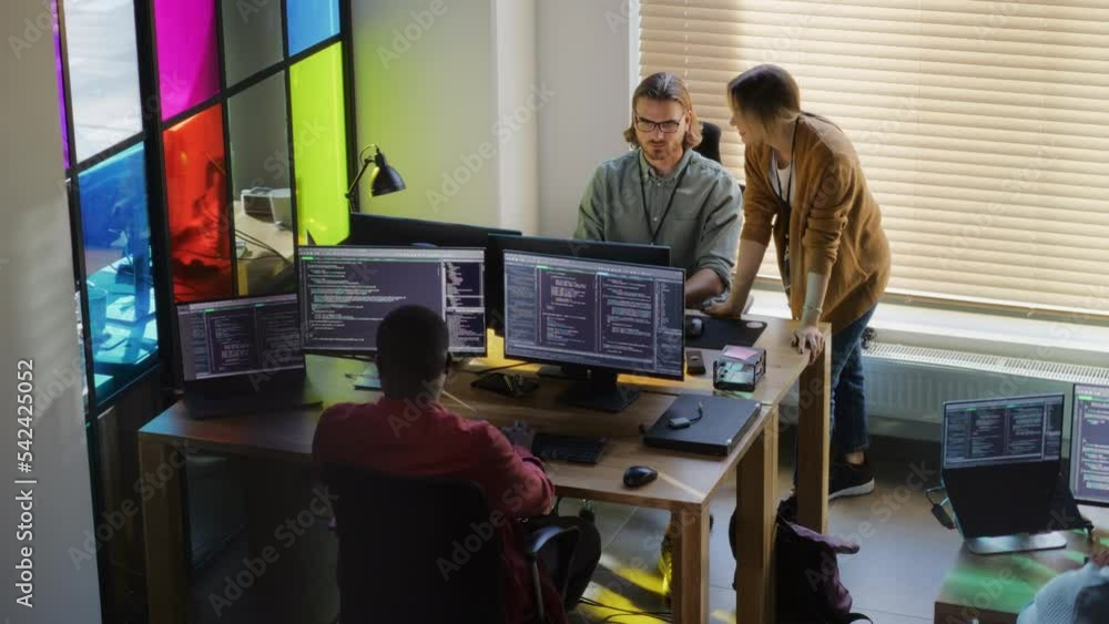 Leinwandbilder Stylish Office Space: Diverse Team Of Developers Writing Code On Desktop Computers With Multiple Monitors. Female Start-up Founder Talks to Senior Data Scientist While Junior Colleagues Coding.
