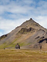Bardur Saga-standbeeld in Arnarstapi en hoge berg op het IJslandse schiereiland Snaefellsnes