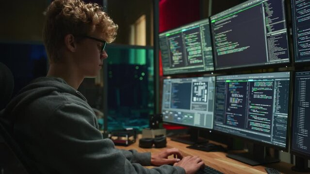 Male Cyber Security Intern Writing Code on Desktop PC With Professional Six Monitors Setup in the Office. Young Caucasian Man Monitors Digital Protection System For an Data Company