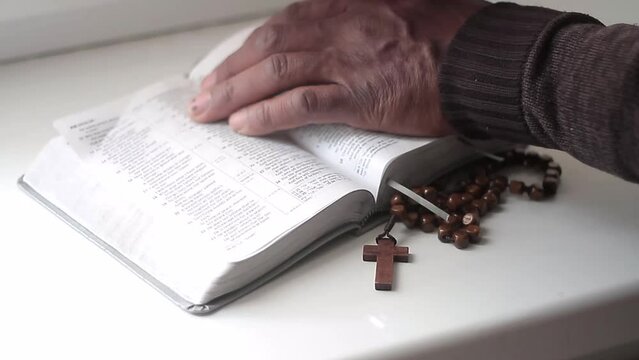 praying to god with hands together with bible and cross black man praying with black background stock video stock footage