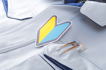 作業服の上に置かれた初心者マーク