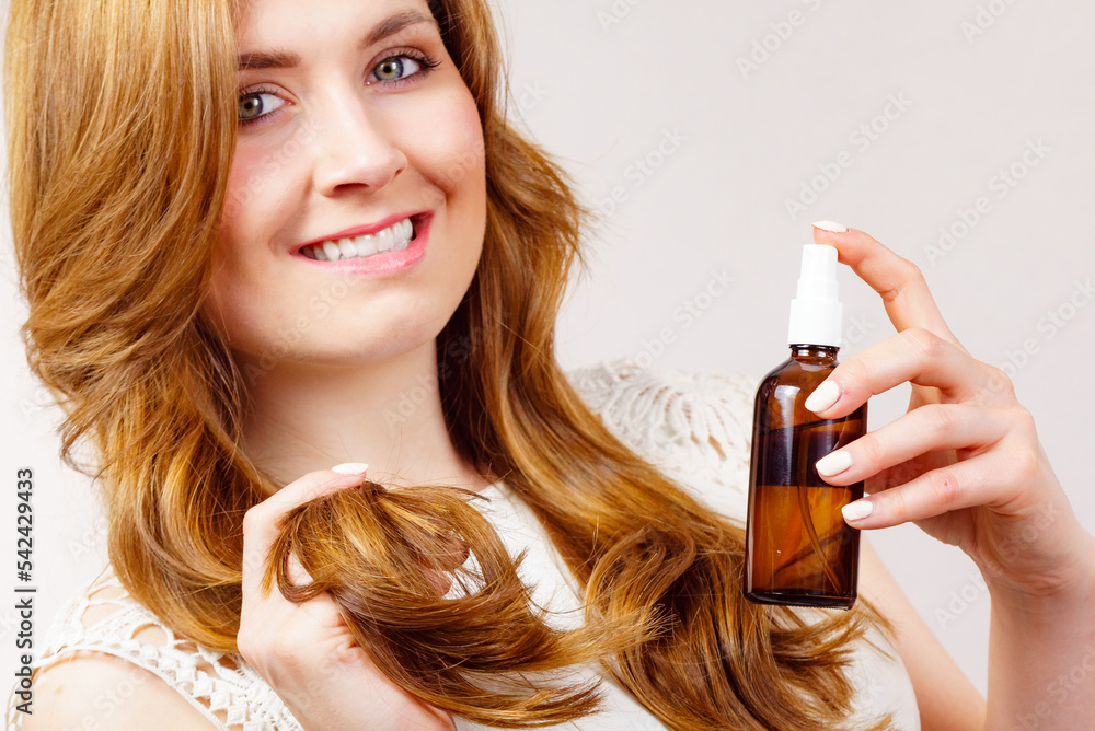 Poster Woman applying hair cosmetic