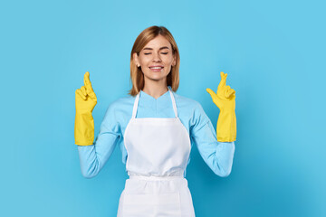 woman in rubber gloves with finger crossed gesture
