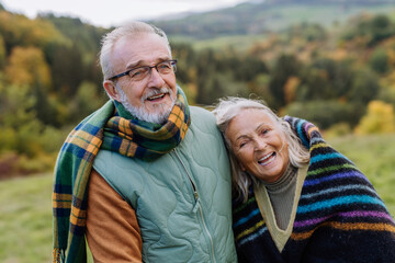 Senior couple in love huging each other in autumn nature.