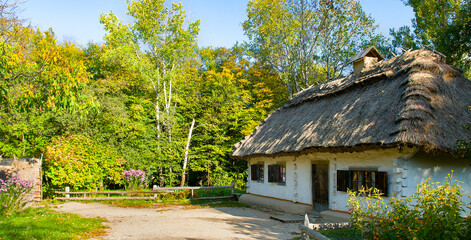 Wooden houses in colored trees taken in park in Pirogovo museum, Kiev, Ukraine. Wide photo.
