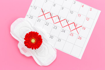 Menstruation period concept with calendar and white pad