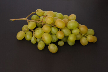 Berries of green bunch of grape on black background.