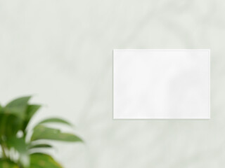 Horizontal white frame mockup on white wall. Poster mockup. Clean, modern, minimal frame. Empty frame Indoor interior, show text or product. frame mockup with shadow and plant. 3d rendering.