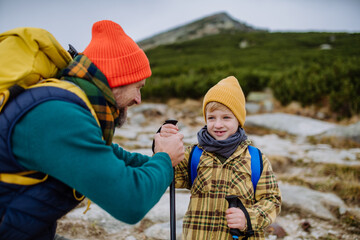 Father with his little son hiking in mountains together.