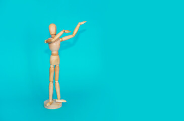 yellow wooden mannequin shows hand gestures on a blue background
