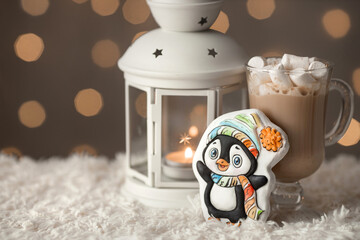 Cup of hot chocolate with gingerbread cookie, candle in lantern and garland lights on background....