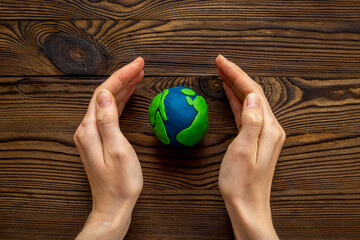 Plasticine world - planet Earth in hands. Eco care concept