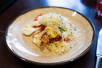 plate with a mix of tomatoes, cheese, eggs with french sauce