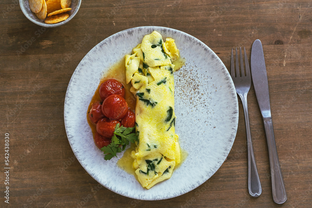 Canvas Prints Omelet with spinach and roasted cherry tomatoes on wooden table, healthy breakfast, top view