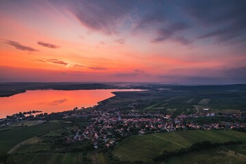 Mesmerizing shot of a seascape near a town under the clouds during the sunset