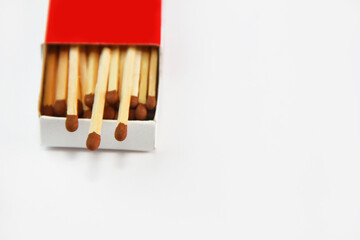 Wooden matches with sulfur heads in a red cardboard box on a white background