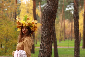 Naklejka premium Young woman with colored autumn leaves in her hair