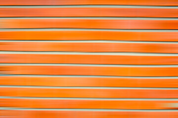 Motion blurred red brick wall texture. orange striped background.