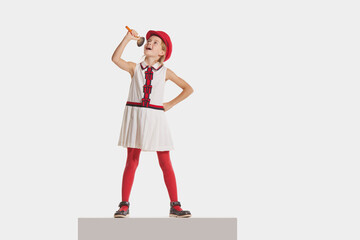 Eras comparison. Modern children in retro lifestyle. Beautiful charming little girl in festive dress isolated on white background. Kids emotions, style, fashion, back to school concept