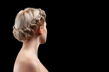 Back view of young woman. Portrait of a nude young white woman blonde. Light curly hair. Stylish hairdo. Isolated on a black