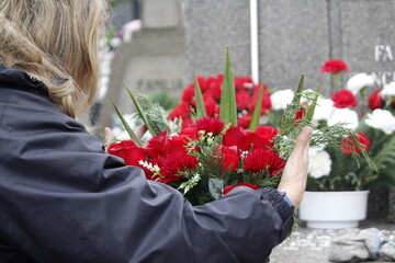 Woman placing flowers on a grave