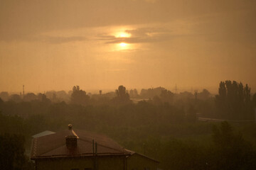 Sunset against dirty rain. Brown color atmosphere