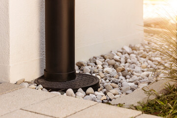 French drain Water Drainage pipe with water Stones Gravel aroud House   - obrazy, fototapety, plakaty