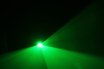 green beam laser beam on dark background	
