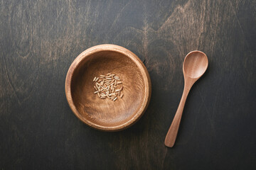 World food crisis concept. Empty old wooden plate on an old dark gloomy background as symbol of global food crisis. Hunger due to lack of grain. Food supply crisis. Place for text. Mock up.