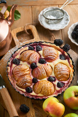 Apple pie. Apple and blackberries cake or pie decorated sugar powder on old wooden table. Delicious dessert for autumn or winter dinner. Autumn pastry dessert. Soft focus.