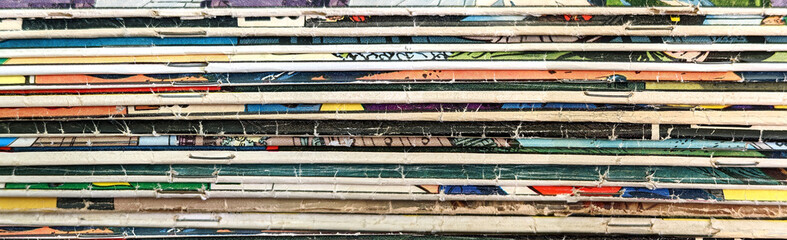 Collection of old vintage comic books stacked in a pile creates colorful background texture of old faded paper pages