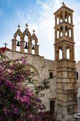 Vertical of Panagia Tourliani monastery in Mykonos, Greece with a beautiful sight of flowering tree