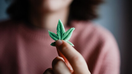 Cbd edible - Woman holding cannabis candy leaf for anxiety treatment - Marijuana alternative...