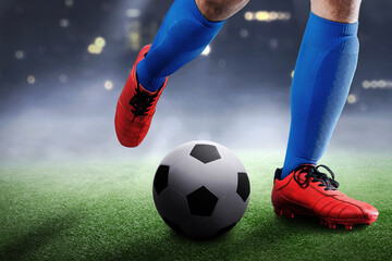 Football player man in a blue jersey kicking the ball