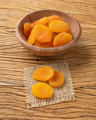 Dried apricots on a bowl over wooden table