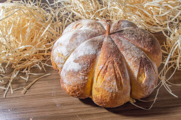 Pumpkin bread made in the shape of a pumpkin on a wooden table