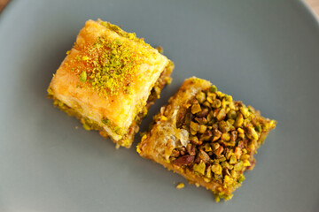 Baklava with pistachio, one of the most beautiful desserts of Turkish cuisine, in gray plate