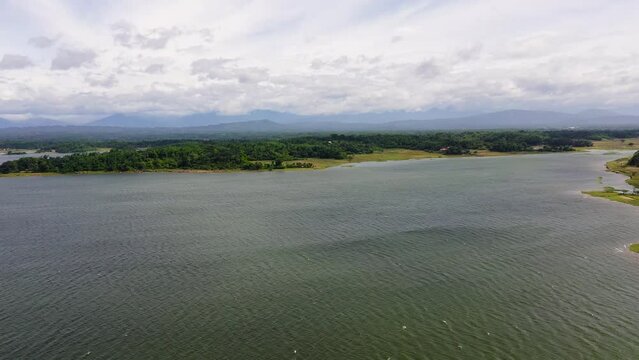 Beautiful lake and mountains in the distance. View of the Paoay Lake, Philippines. Big lake on a tropical island. Summer and travel vacation concept.