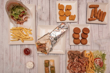 set of kebab food dishes with french fries, falafel, fried nuggets, lamb meat and baklava, snacks and sauces