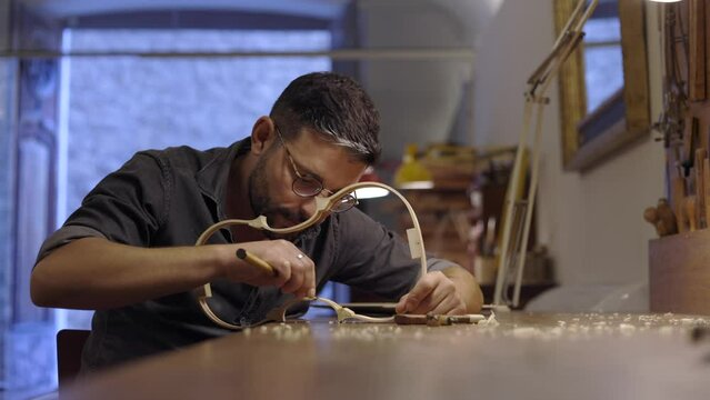 Luthier creating violin ribs in workshop