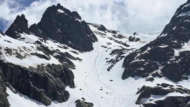 People freeriding down rocky slope of snowy mountain