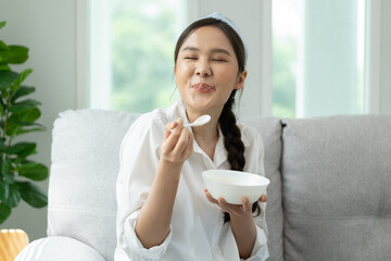 happy young woman feeling joy with delicious food her face have a big smile on the sofa at home